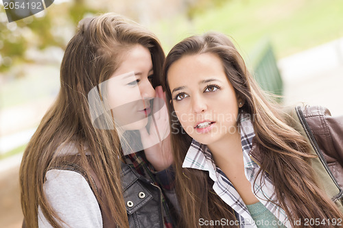 Image of Mixed Race Woman Whispering Secrets Outside