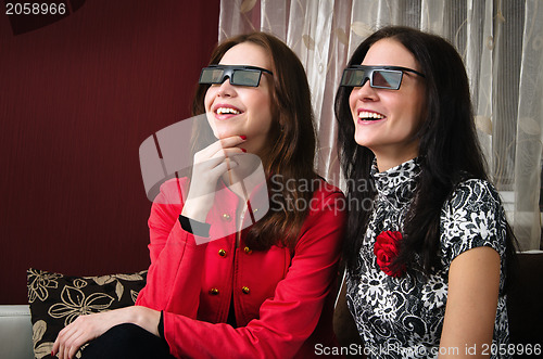 Image of young beautiful women watching 3D TV at home