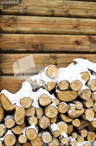 Image of Birch fire wood at a wall of the house in winter