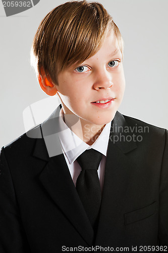 Image of Smiling young boy wearing black suit