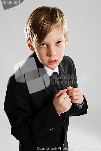 Image of Serious young boy wearing black suit