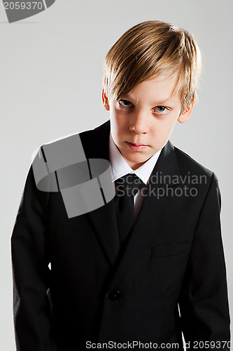 Image of Serious young boy wearing black suit