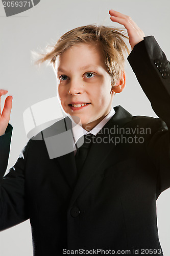 Image of Smiling young boy wearing black suit