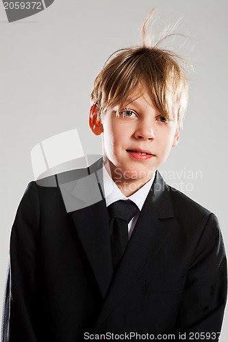 Image of Happy relaxed young boy in black suit