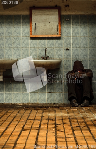 Image of An abandoned industrial interior with a depressed man