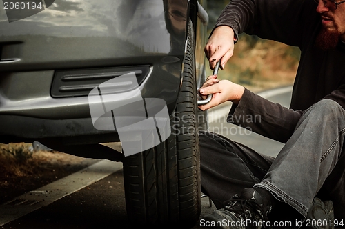 Image of Young man repairing car