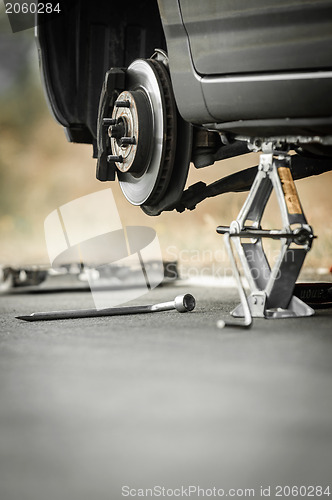 Image of Car without tire on the road