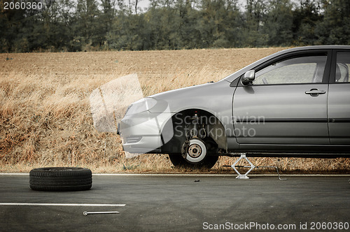 Image of Car without tire on the road