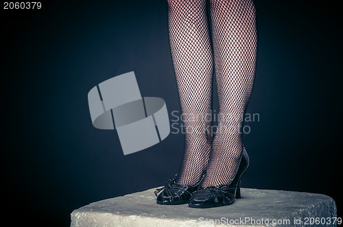 Image of Legs of a youn woman against dark background