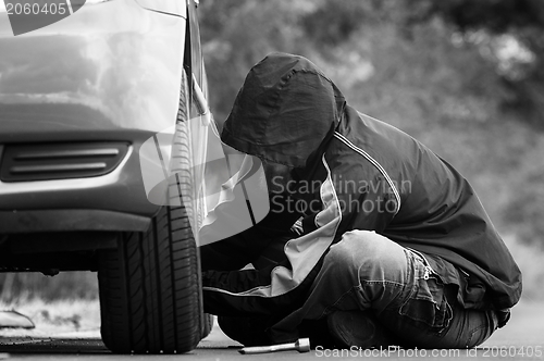 Image of Young adult inspecting the wheel