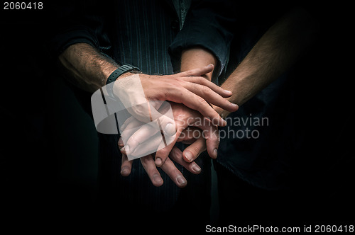 Image of Group of young adults making a pile of hands