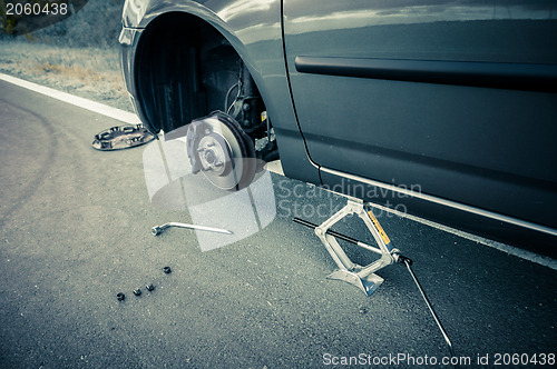 Image of Car without tire on the road