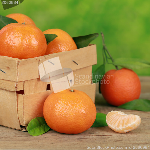 Image of Tangerines with leaves in a wooden box