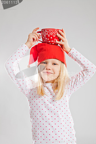 Image of Happy young girl holding big cup on head