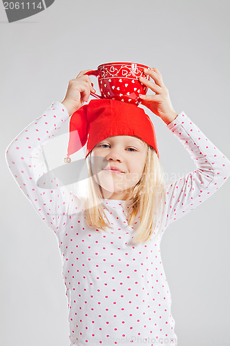 Image of Happy young girl holding big cup on head