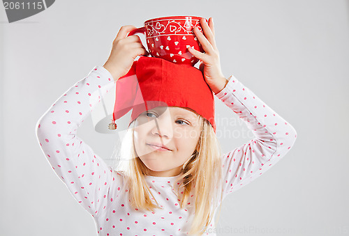 Image of Happy young girl holding big cup on head