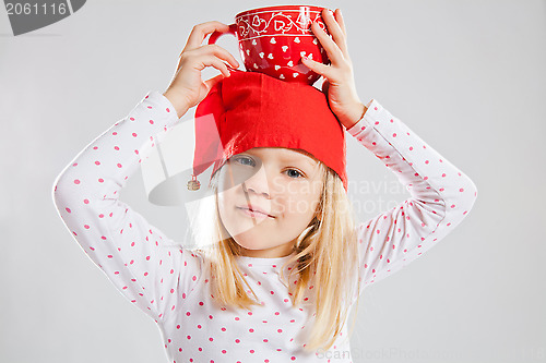 Image of Happy young girl holding big cup on head