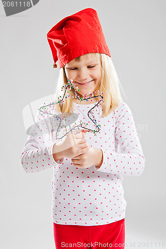 Image of Happy young girl holding Christmas star decoration