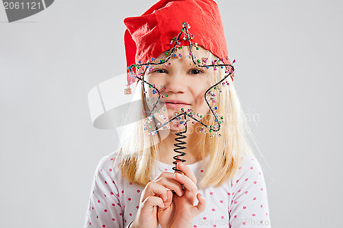 Image of Happy young girl holding Christmas star decoration