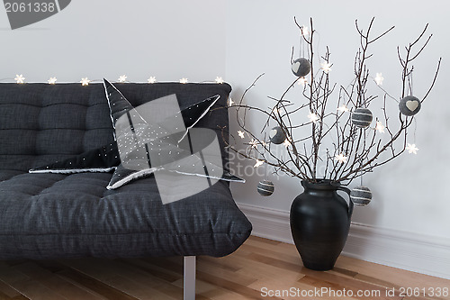 Image of Gray sofa, winter decorations and cozy lights