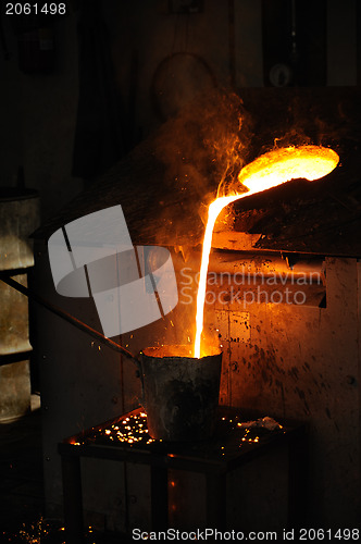 Image of Foundry - Molten metal poured from lathe for casting