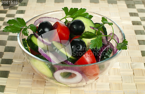 Image of Salad in a glass bowl on a wooden base