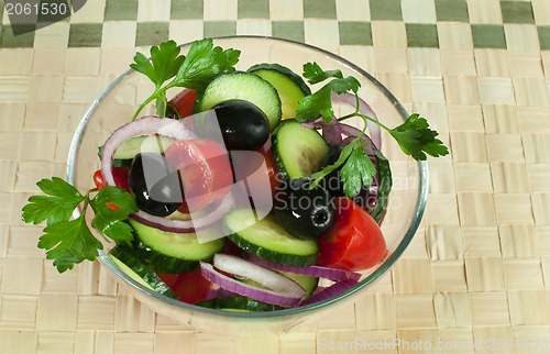 Image of Salad in a glass bowl on a wooden base