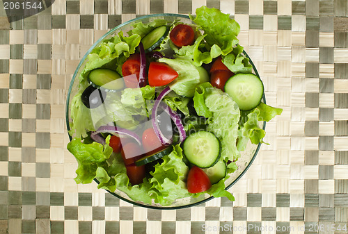 Image of Salad in a glass bowl on a wooden base