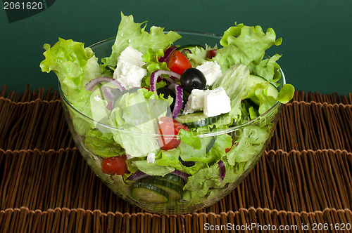 Image of Salad in a glass bowl on a wooden base