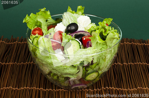 Image of Salad in a glass bowl on a wooden base