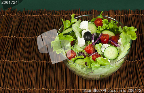 Image of Salad in a glass bowl on a wooden base