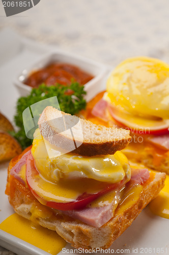 Image of eggs benedict on bread with tomato and ham