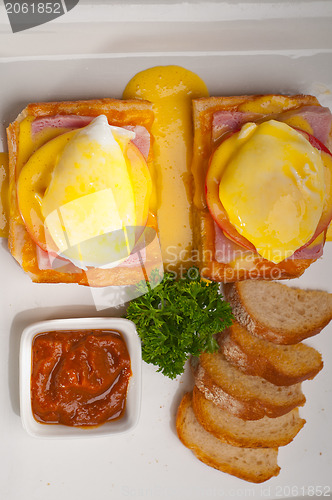 Image of eggs benedict on bread with tomato and ham