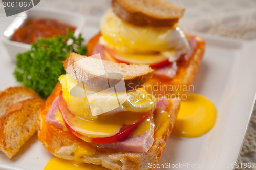 Image of eggs benedict on bread with tomato and ham