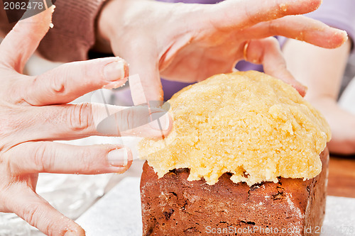 Image of Hands decorating christmas cake closeup