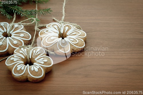 Image of Gingerbread cookies hanging over wooden background 