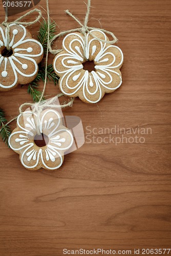 Image of Gingerbread cookies hanging over wooden background 