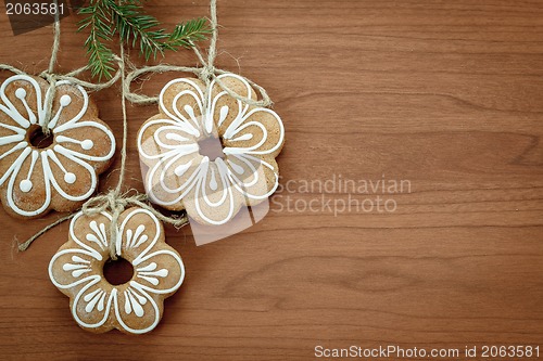 Image of Gingerbread cookies hanging over wooden background 