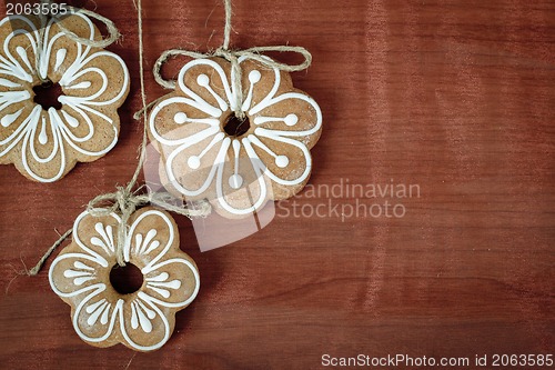 Image of Gingerbread cookies hanging over wooden background 