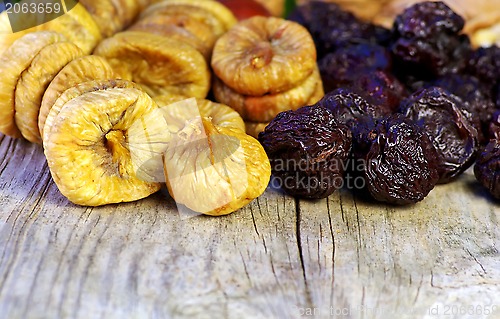Image of dried plums and figs in wooden table