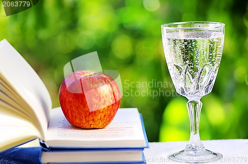 Image of Apple on open book and water cup