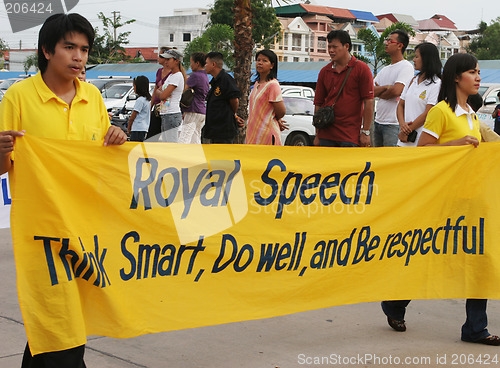 Image of Thai people carry a banner to pay respect to the King during a p