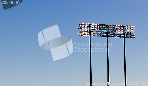 Image of Stadium lights over a blue sky