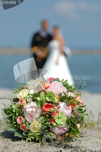 Image of Bouquet, bride and groom. Focus on the bouquet.