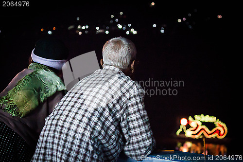 Image of Asian senior couple view river decorated light