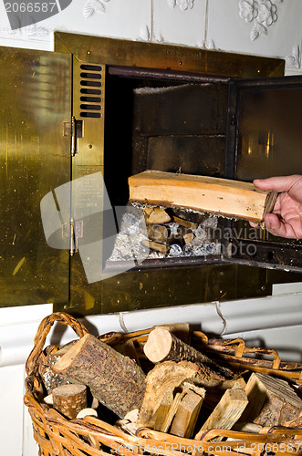 Image of Puting firewood into fireplace