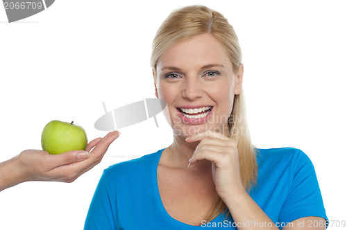 Image of Attractive woman is being offered a green apple