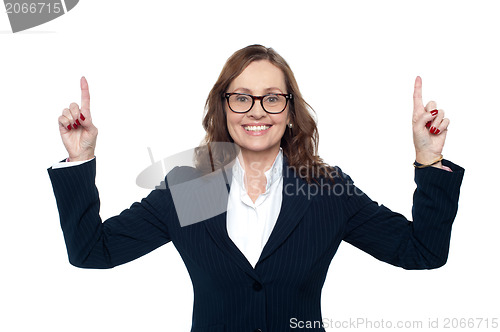 Image of Smiling corporate woman pointing upwards