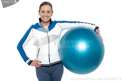 Image of Pretty woman holding big blue pilate ball