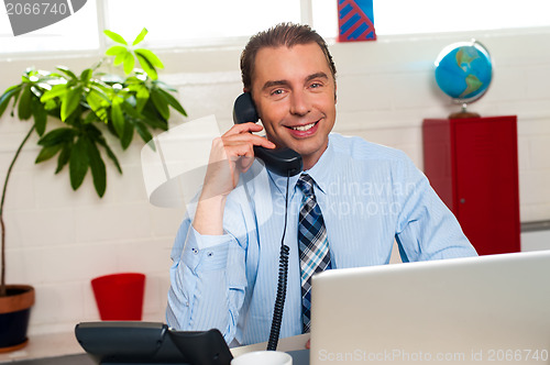 Image of Smiling manager in middle of business interactions